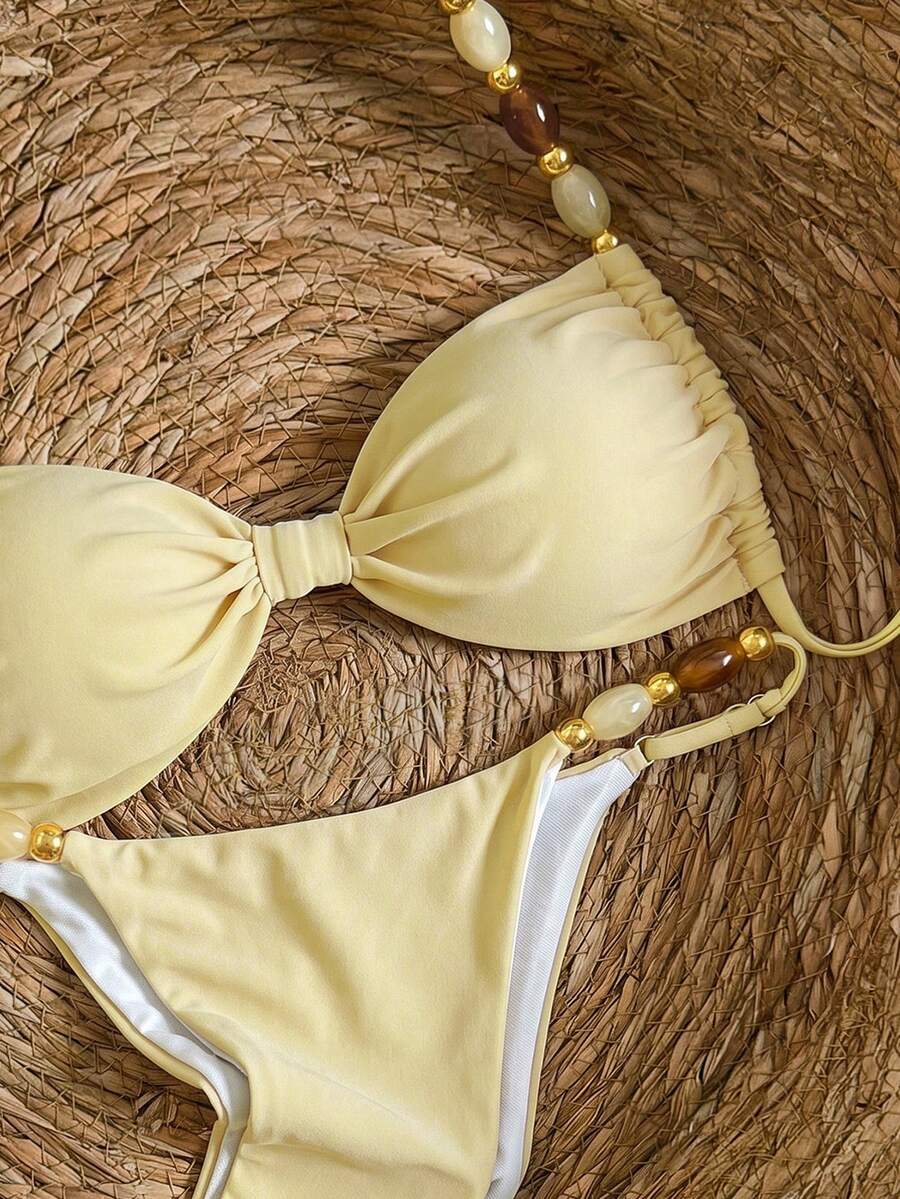 Women's green halter neck bikini set featuring color-block beaded shoulder straps, back tie detail, and high cut bottoms.