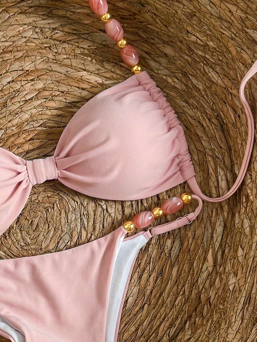 Women's green halter neck bikini set featuring color-block beaded shoulder straps, back tie detail, and high cut bottoms.