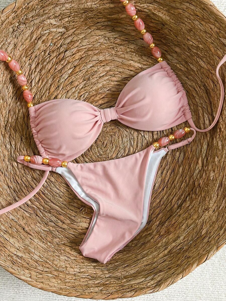 Women's green halter neck bikini set featuring color-block beaded shoulder straps, back tie detail, and high cut bottoms.