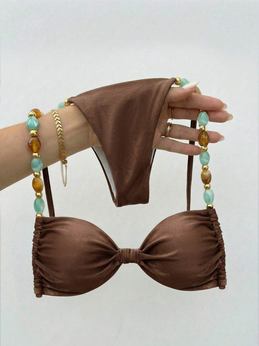 Women's green halter neck bikini set featuring color-block beaded shoulder straps, back tie detail, and high cut bottoms.