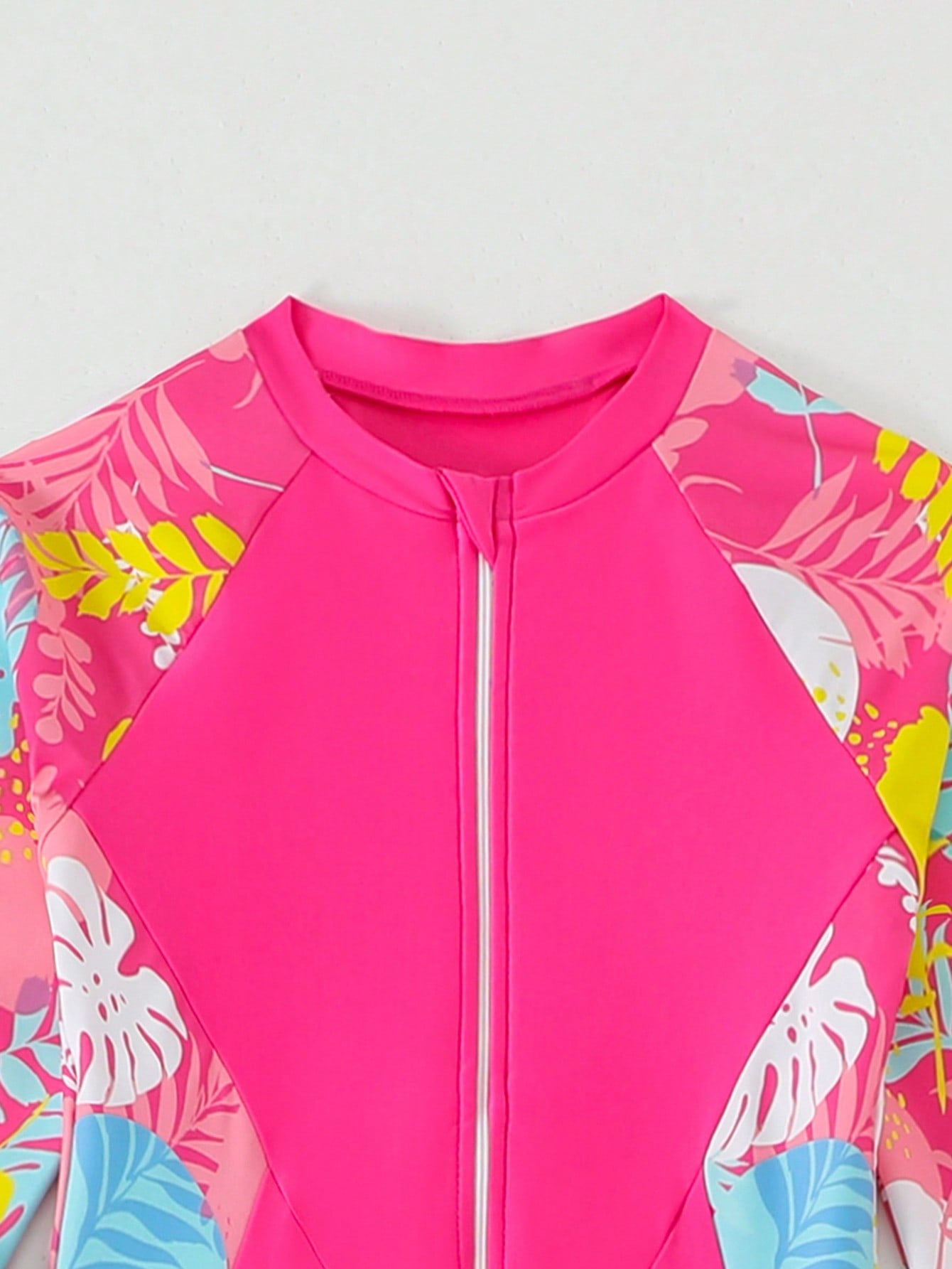 Tween girls black one-piece swimsuit with long sleeves, high neck, zipper detail, graphic leopard heart print, and fitted full-coverage swimwear style.