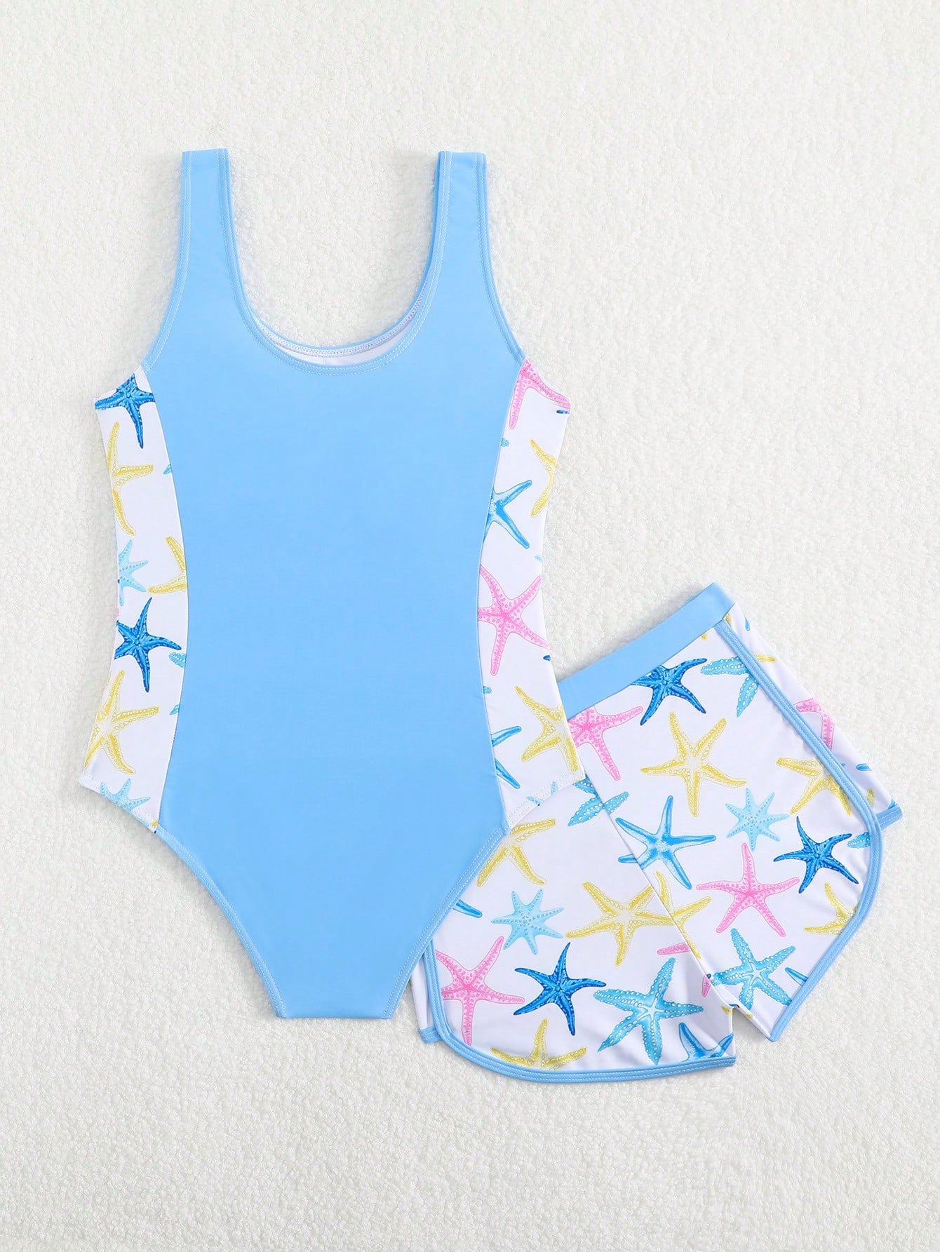 Tween girls 2-piece swimsuit set in black with full floral and plant print, featuring a sleeveless scoop-neck swim top and matching shorts-style bottoms.