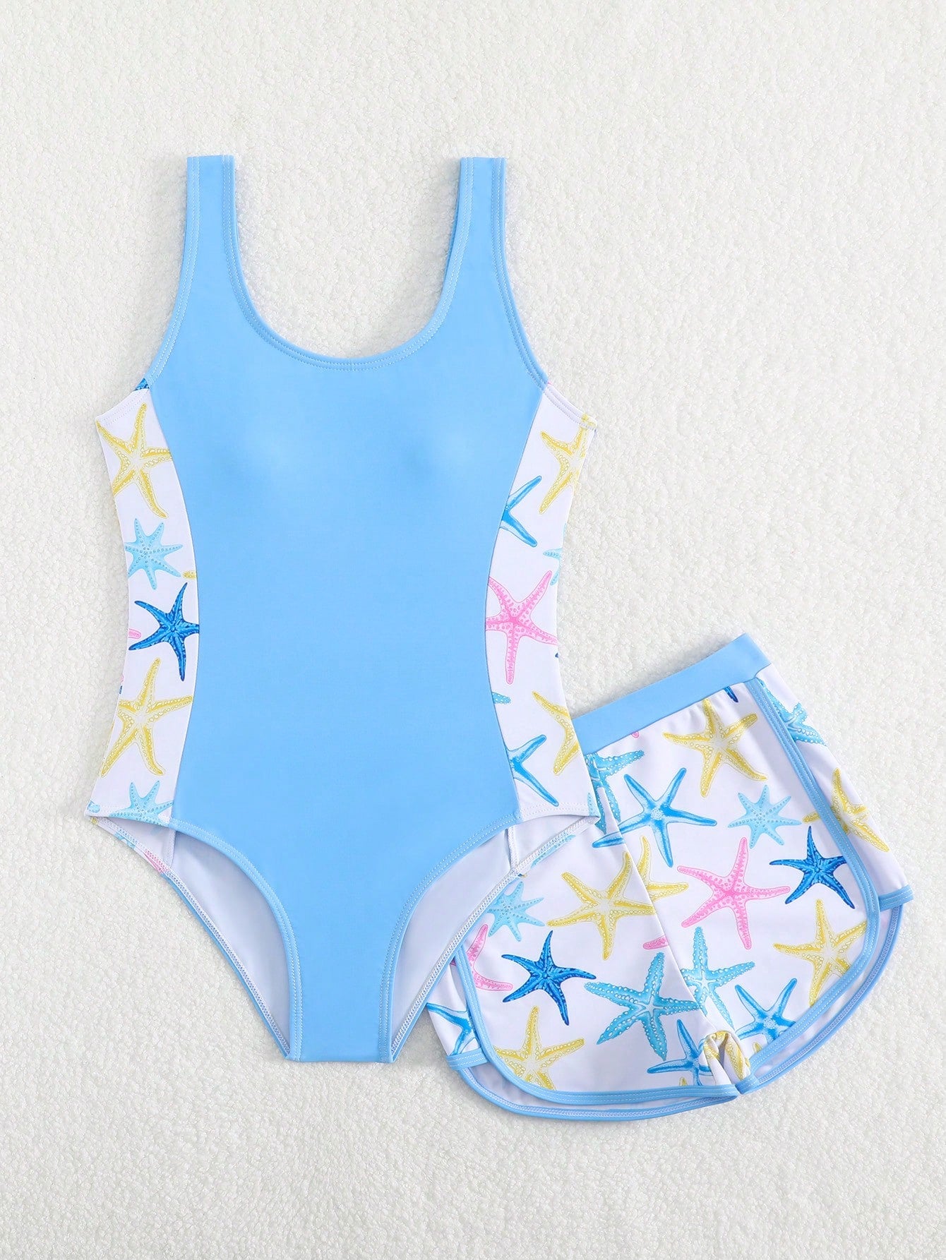 Tween girls 2-piece swimsuit set in black with full floral and plant print, featuring a sleeveless scoop-neck swim top and matching shorts-style bottoms.