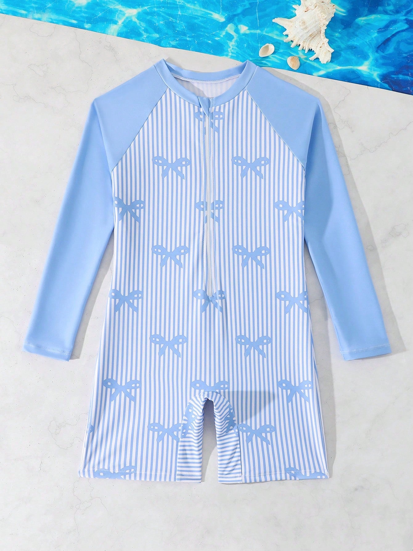 Tween girls one-piece swimsuit featuring a high neck, long sleeves, and shorts bottom, with a back zipper and strawberry plaid digital print on stretch knit fabric. Designed for swimming, vacation, and summer wear.