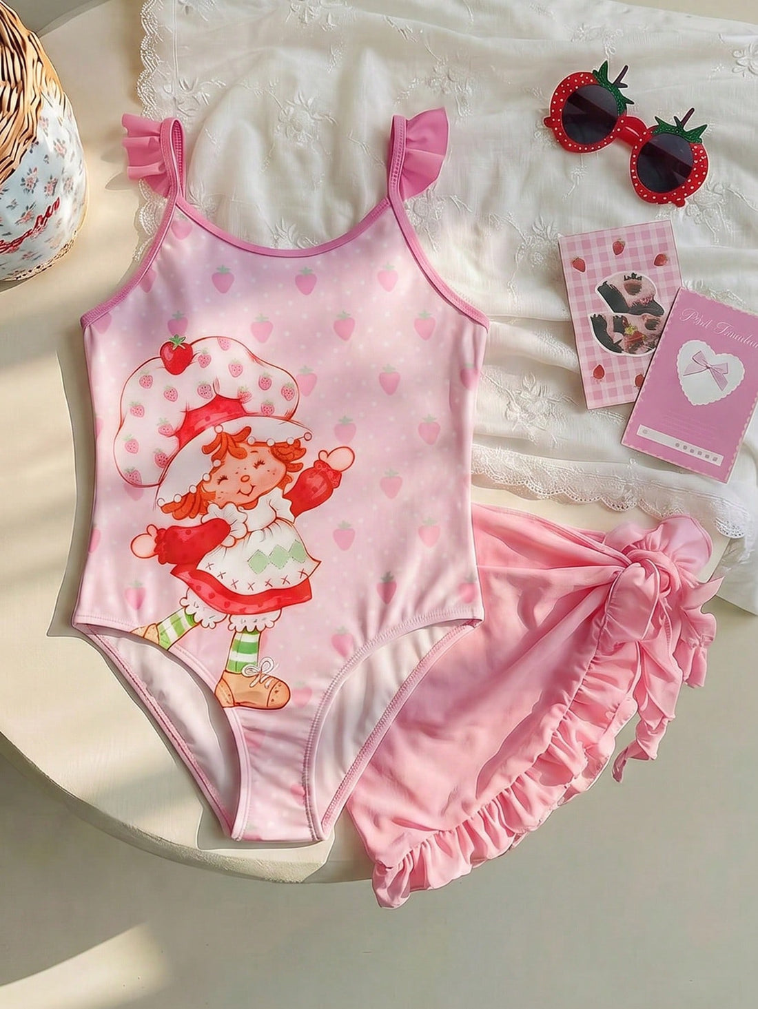 Pink tween girls one-piece swimsuit with ruffle details, spaghetti straps, plant pattern, and matching cover-up skirt set for summer beach wear