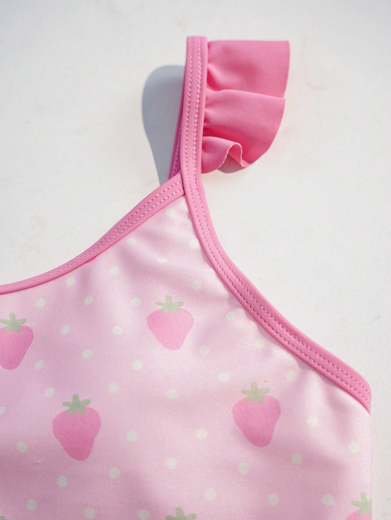 Pink tween girls one-piece swimsuit with ruffle details, spaghetti straps, plant pattern, and matching cover-up skirt set for summer beach wear