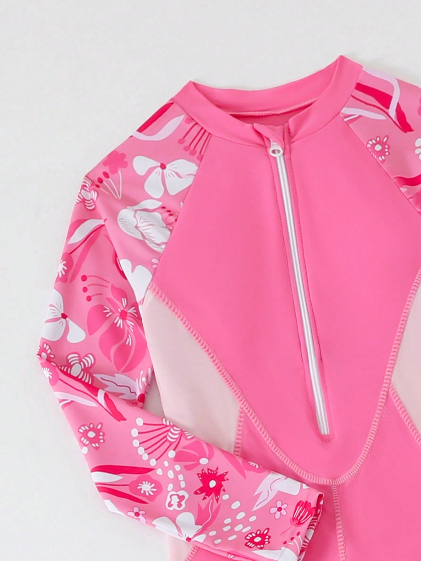Tween girls black one-piece swimsuit with long sleeves, high neck, zipper detail, graphic leopard heart print, and fitted full-coverage swimwear style.