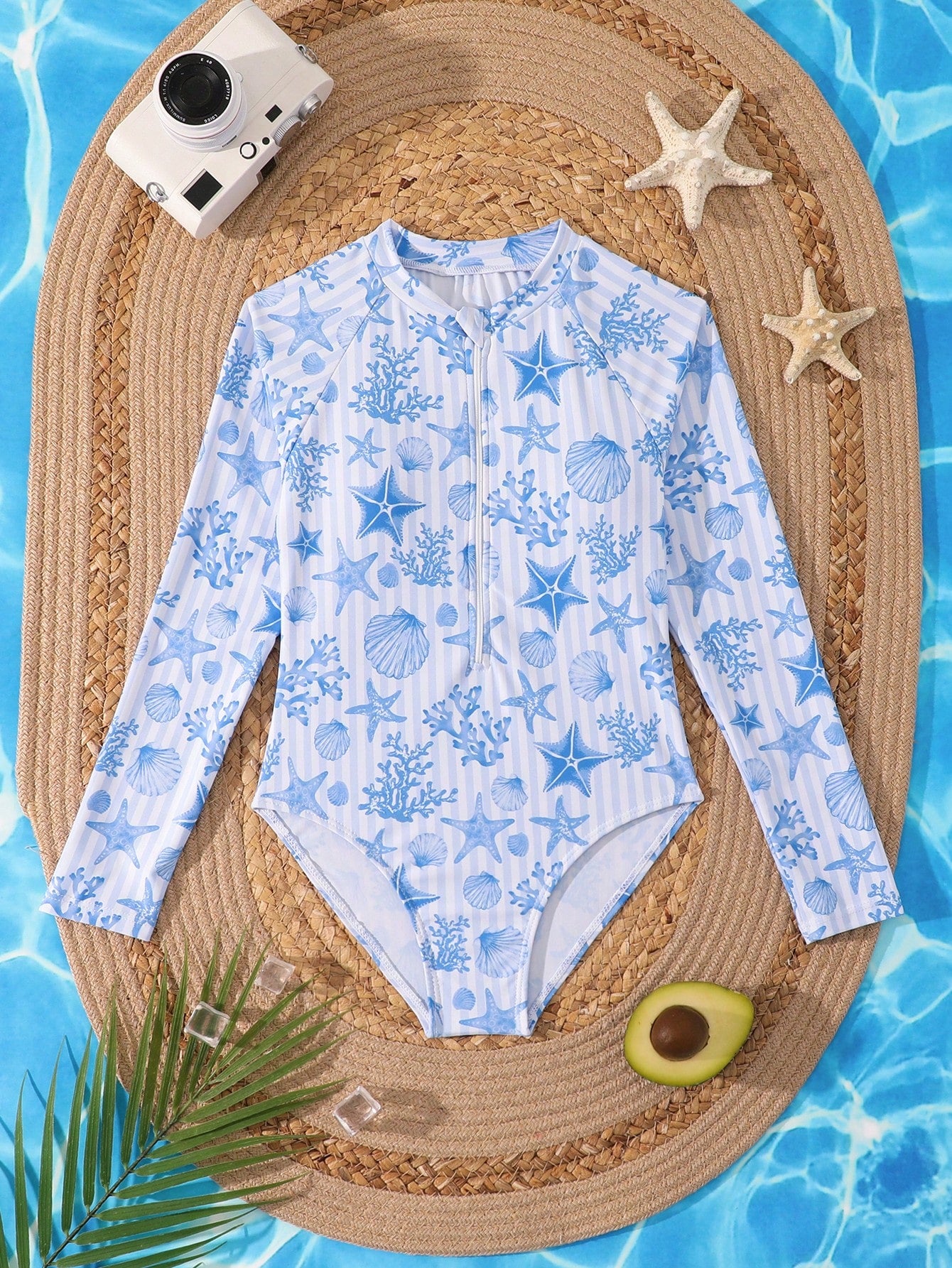 Tween girls one-piece rash guard swimsuit with long sleeves, high neck, front zipper, and ocean shell graphic print in a fitted style for beach, swimming, and vacation wear.