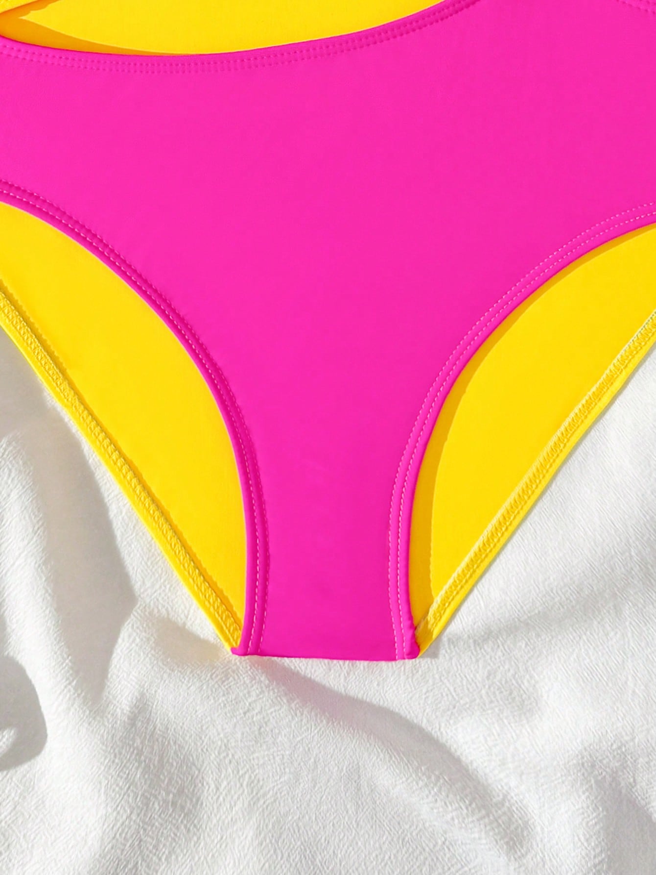 Black one-piece swimsuit for tween girls with cut out detail, spaghetti straps, high waist bottom, wireless bra, and fitted vacation swimwear style.