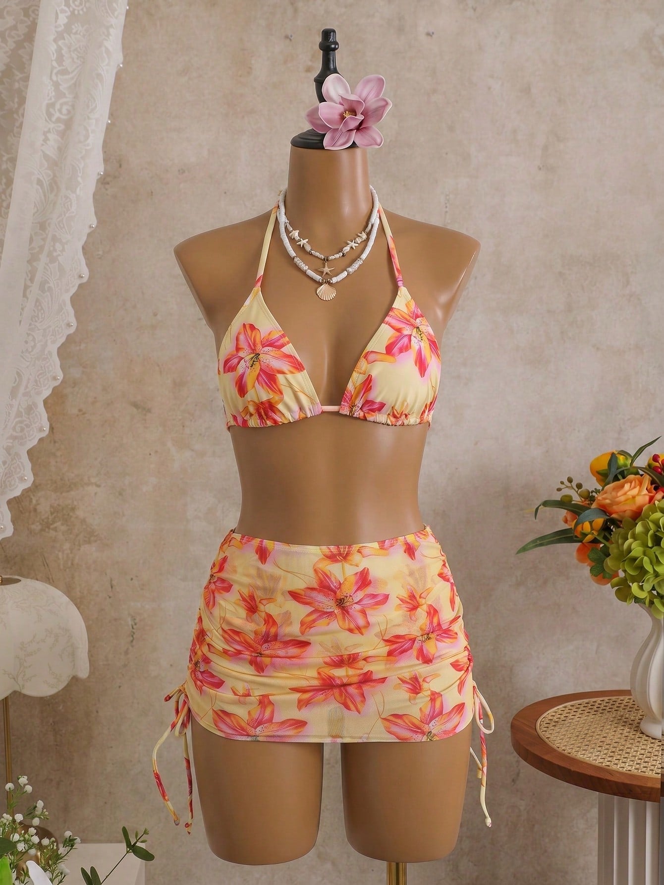 Women's black 3-piece bikini set featuring a halter triangle top with removable padding, high-waisted bottoms, and a knee-length mesh skirt with tie details.