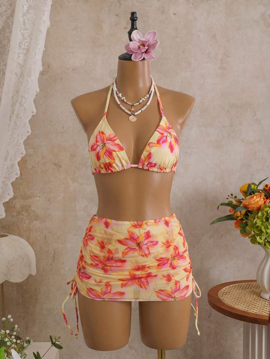 Women's black 3-piece bikini set featuring a halter triangle top with removable padding, high-waisted bottoms, and a knee-length mesh skirt with tie details.