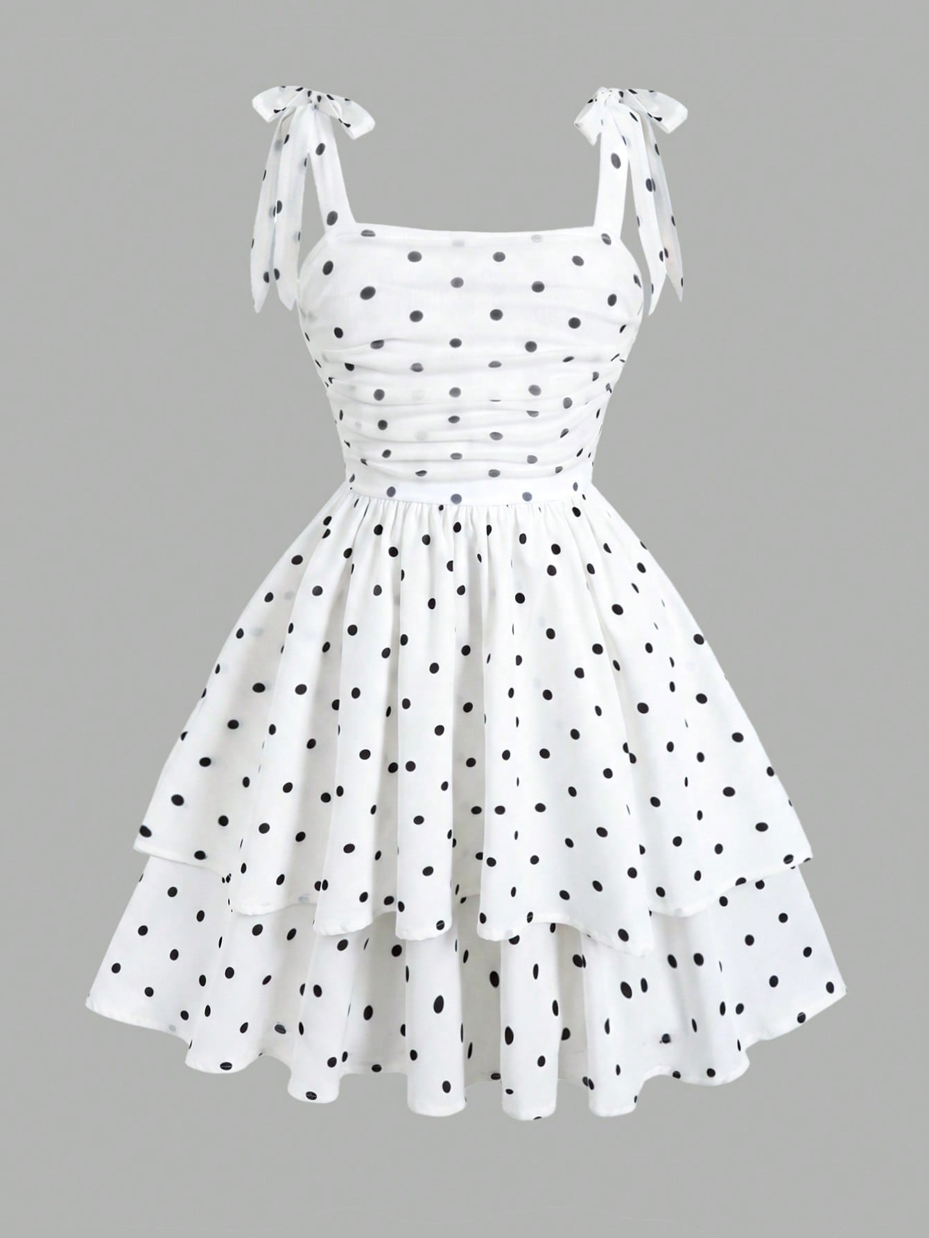 Black and white polka dot cami dress for tween girls featuring sleeveless straps, a shirred high waist, flared hem, and slim fit silhouette.