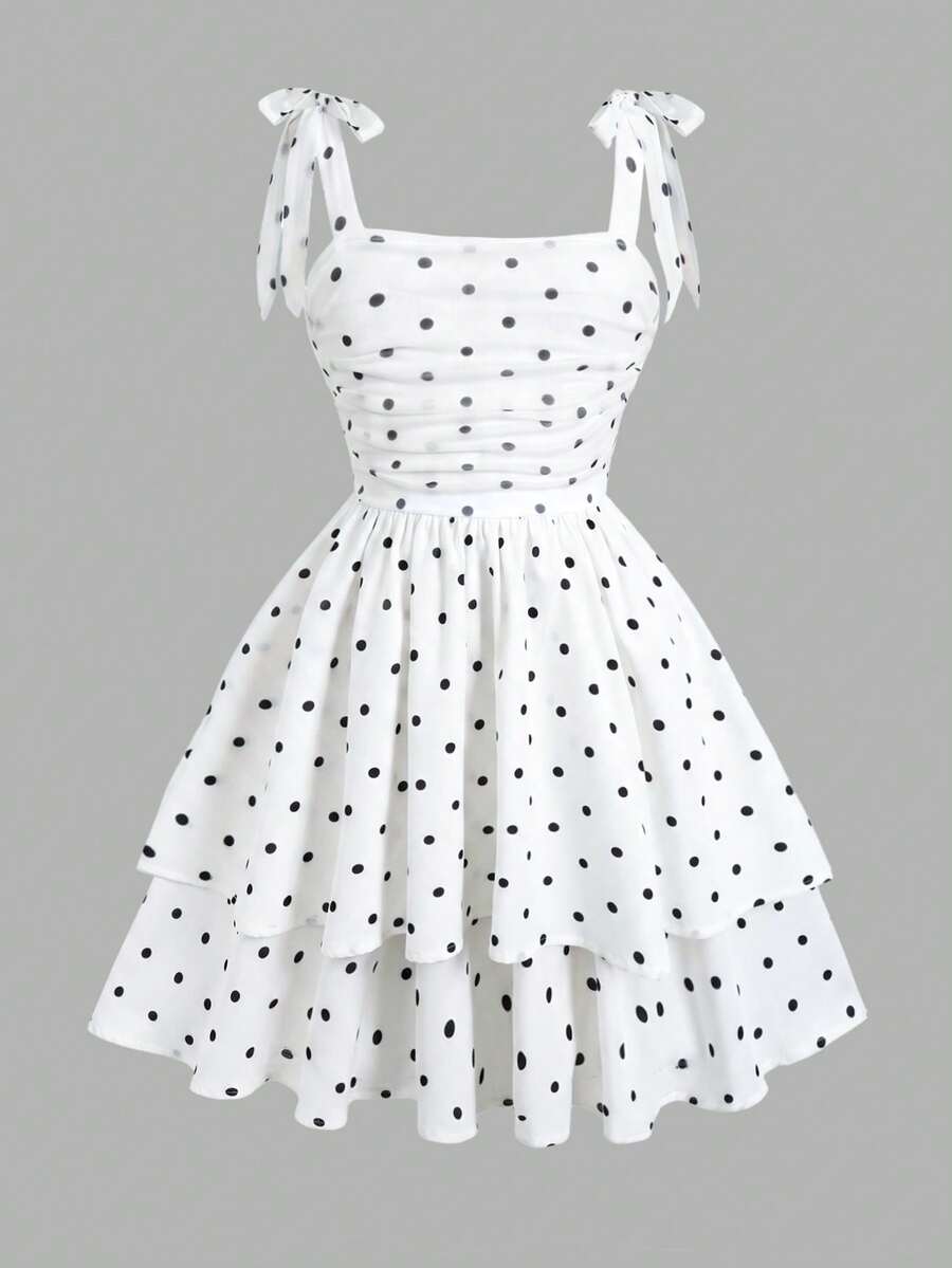 Black and white polka dot cami dress for tween girls featuring sleeveless straps, a shirred high waist, flared hem, and slim fit silhouette.