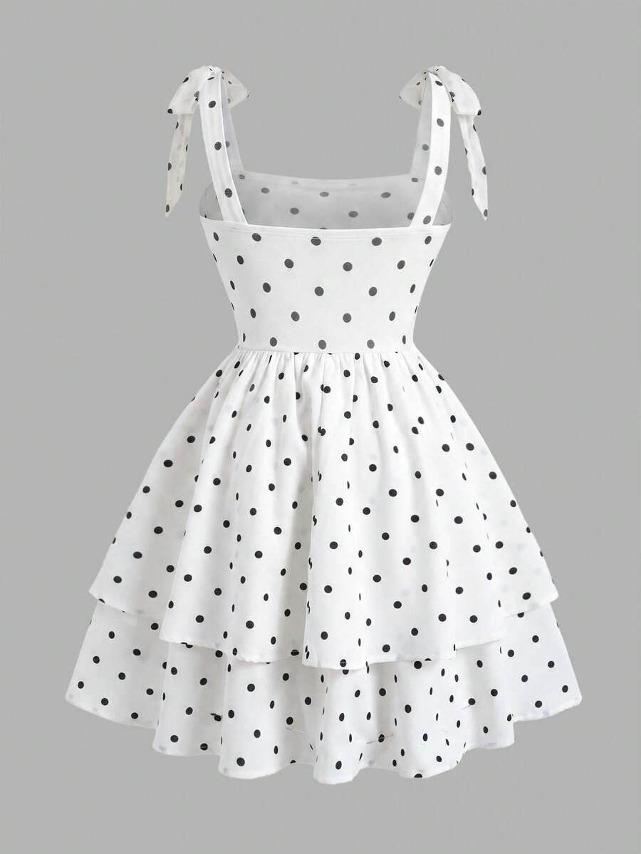 Black and white polka dot cami dress for tween girls featuring sleeveless straps, a shirred high waist, flared hem, and slim fit silhouette.