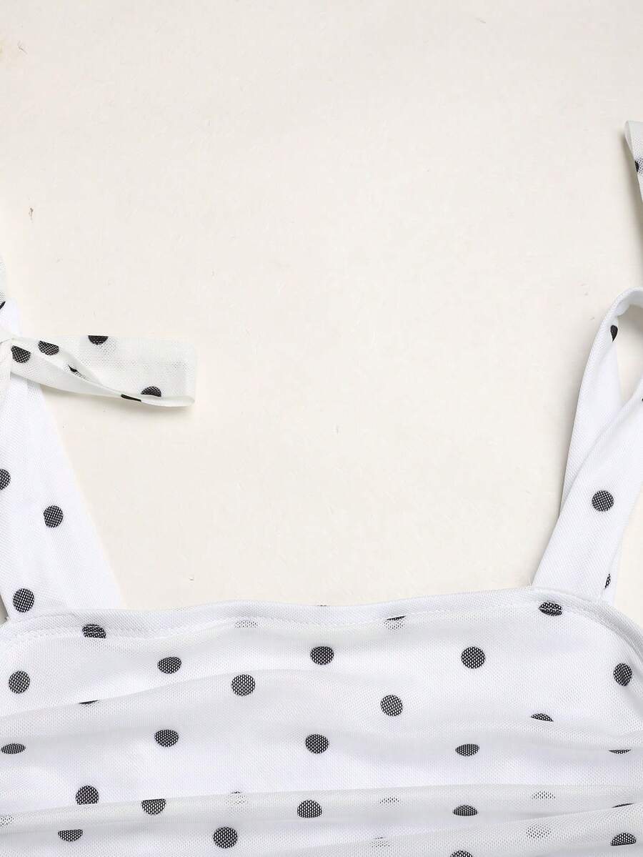 Black and white polka dot cami dress for tween girls featuring sleeveless straps, a shirred high waist, flared hem, and slim fit silhouette.