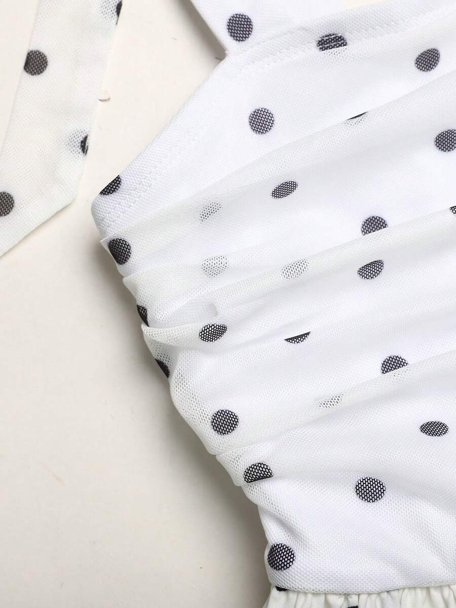 Black and white polka dot cami dress for tween girls featuring sleeveless straps, a shirred high waist, flared hem, and slim fit silhouette.