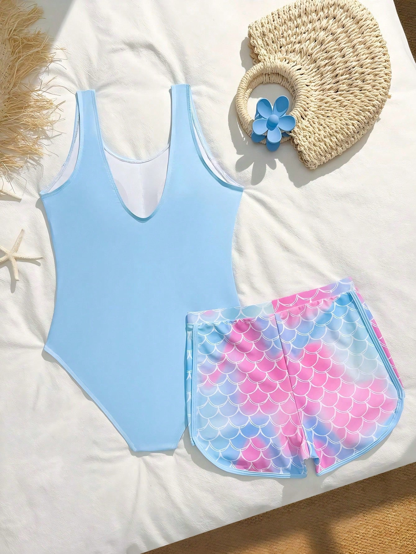 Tween girls 2-piece swimsuit set in black with full floral and plant print, featuring a sleeveless scoop-neck swim top and matching shorts-style bottoms.