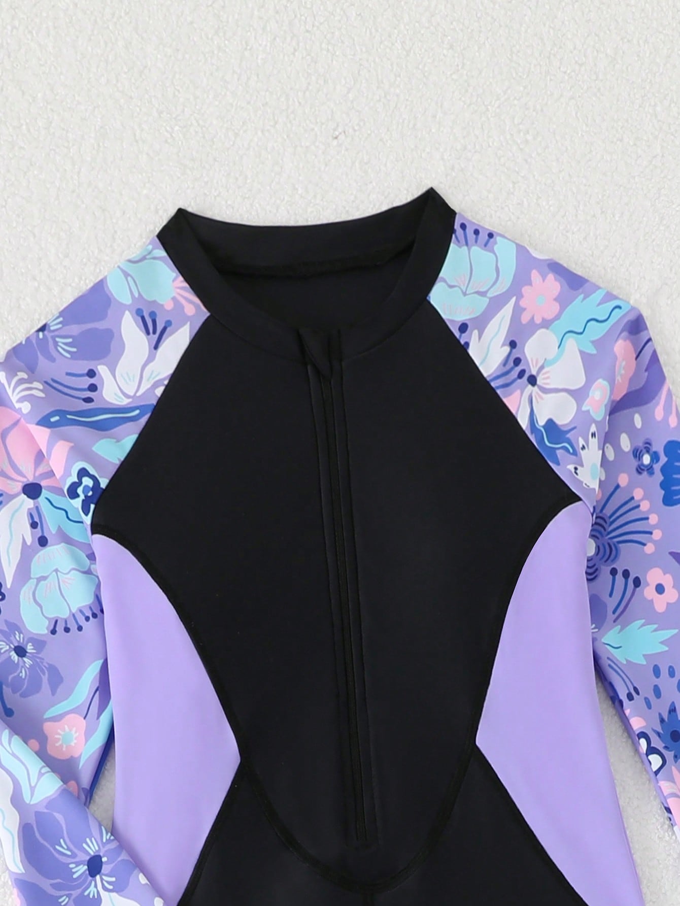 Tween girls black one-piece swimsuit with long sleeves, high neck, zipper detail, graphic leopard heart print, and fitted full-coverage swimwear style.