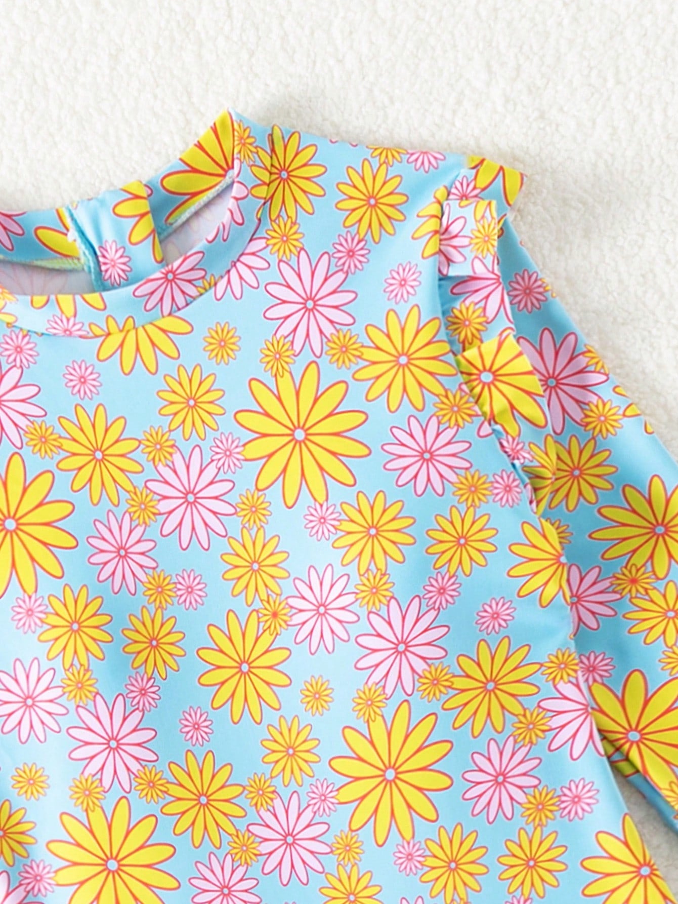 Tween girls' multicolor floral one-piece swimsuit with ruffle trim, high neck, zipper detail, short bottom, and lined high-stretch swim fabric.