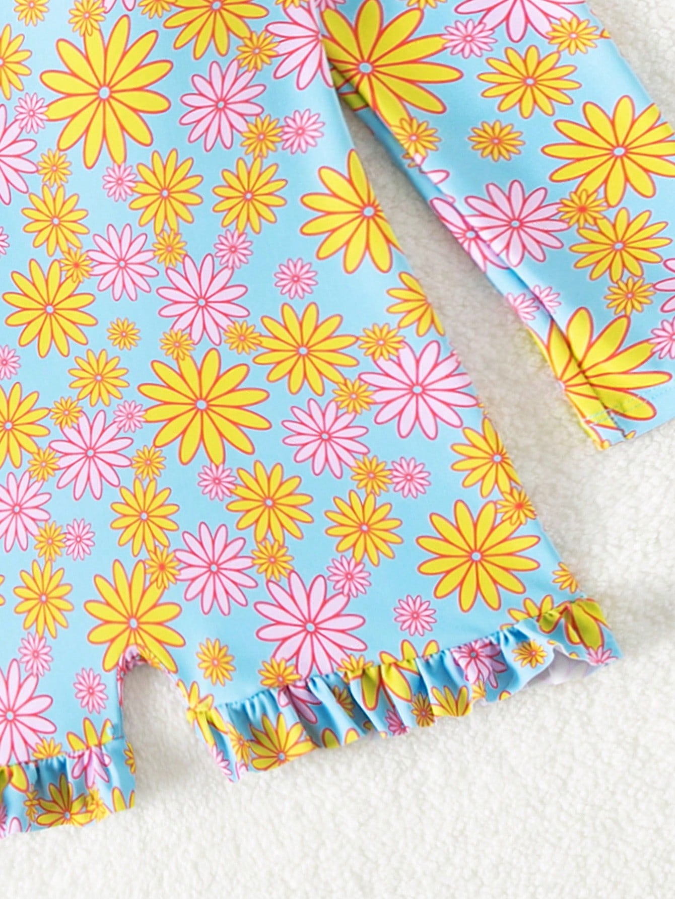 Tween girls' multicolor floral one-piece swimsuit with ruffle trim, high neck, zipper detail, short bottom, and lined high-stretch swim fabric.