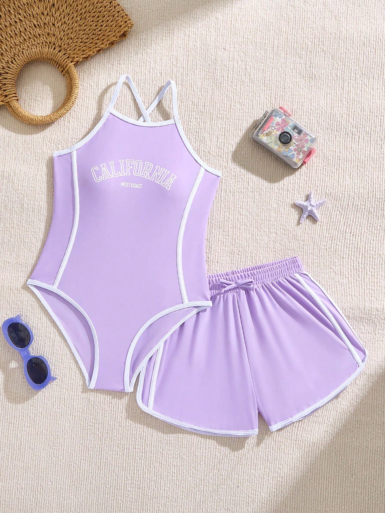 Girls' mauve purple one-piece swimsuit with swim shorts, spaghetti straps, contrast piping, letter pattern, and sleeveless vacation swimwear design.