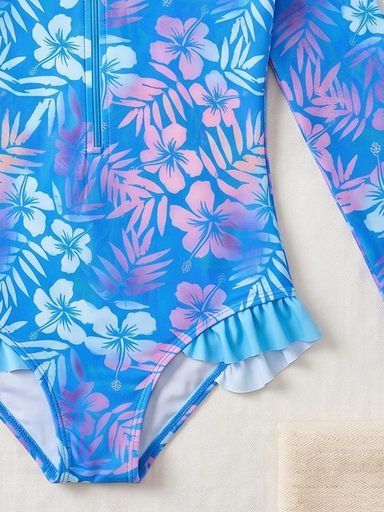 Girls' floral one-piece swimsuit with ruffle trim, high neck, and zipper front for beach and resort wear
