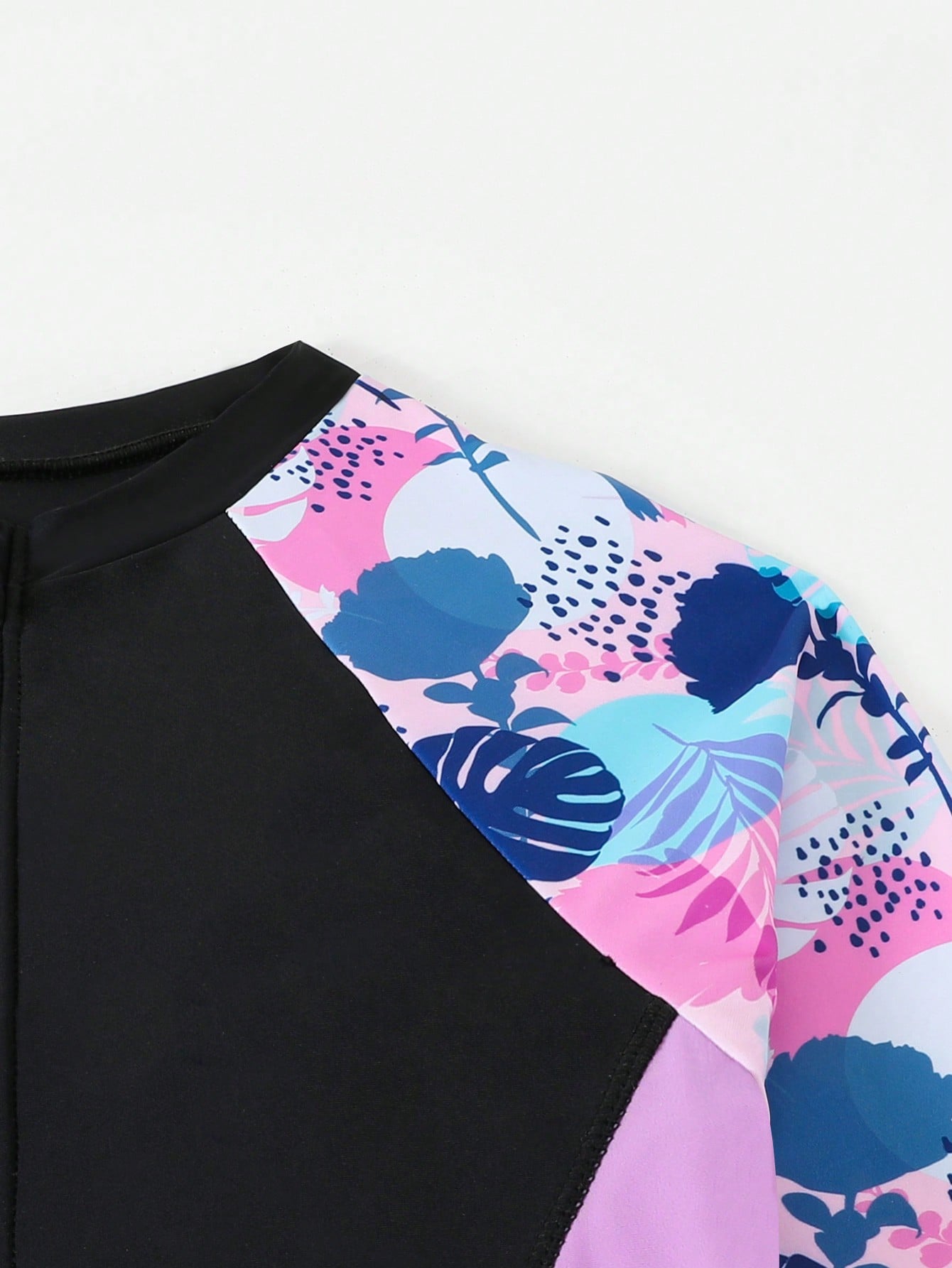Tween girls black one-piece swimsuit with long sleeves, high neck, zipper detail, graphic leopard heart print, and fitted full-coverage swimwear style.