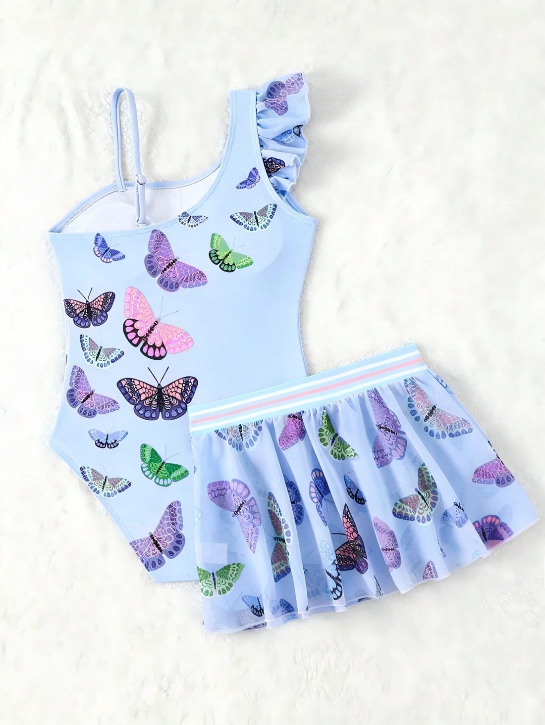 Girls yellow one-piece swimsuit with asymmetrical neckline, ruffle detail, sleeveless fitted style, and skirt bottom for beach and pool vacations.