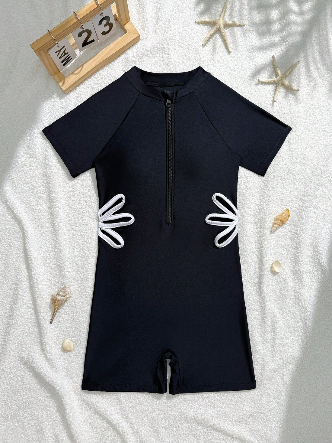 Black tween girls one-piece swimsuit with zipper front, short sleeves, high neck, hollow-out detail, and shorts-style bottom for beach, pool, surfing, and swimming.
