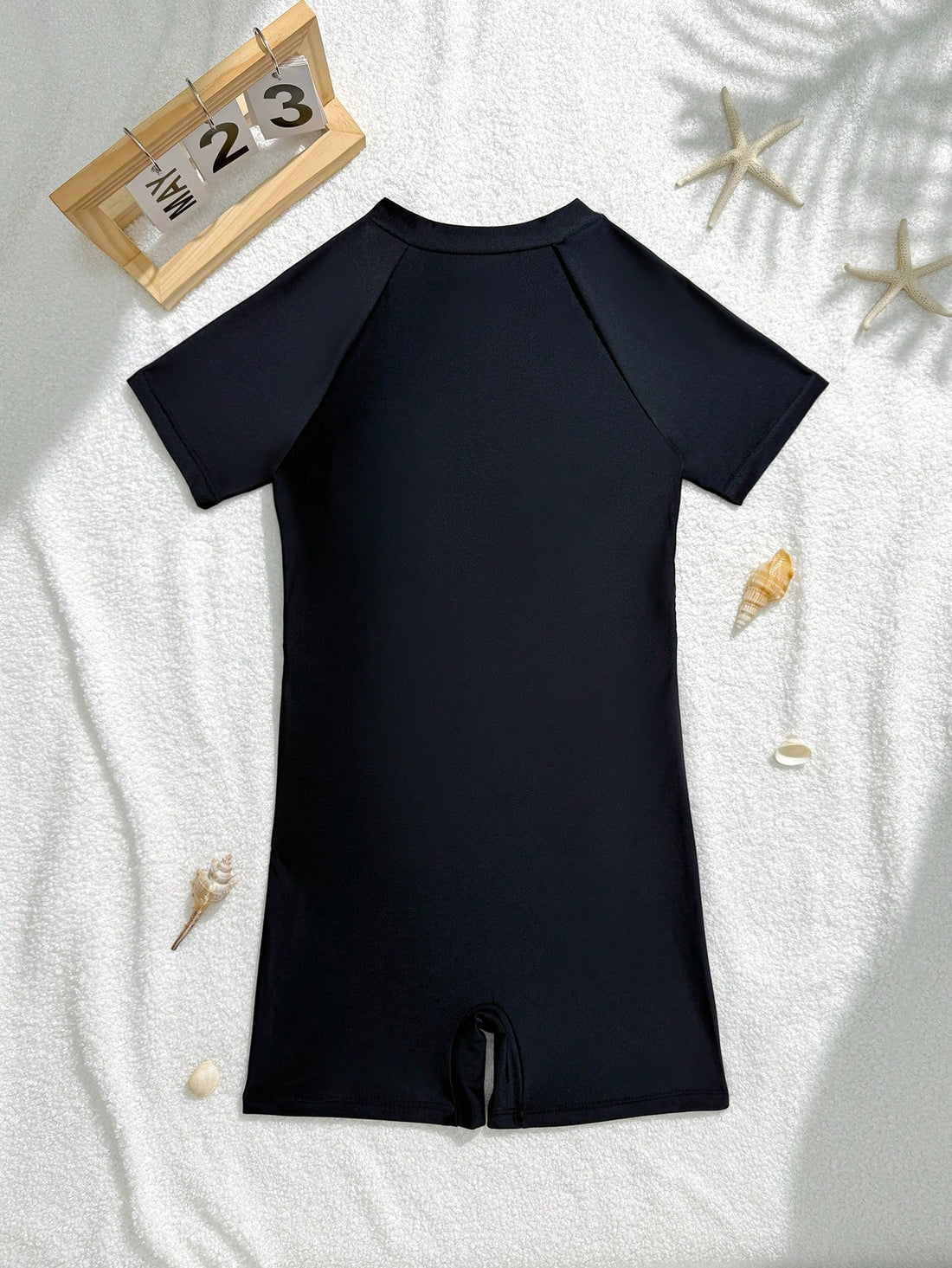 Black tween girls one-piece swimsuit with zipper front, short sleeves, high neck, hollow-out detail, and shorts-style bottom for beach, pool, surfing, and swimming.