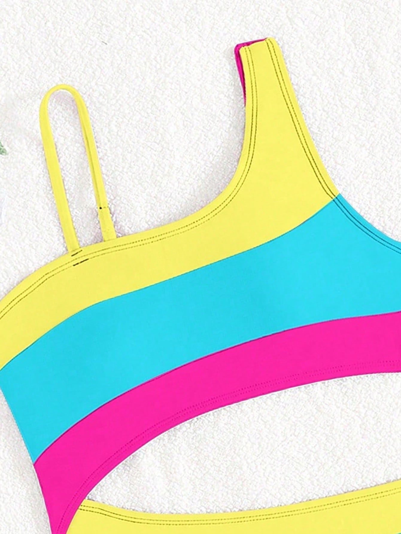 Black one-piece swimsuit for tween girls with cut out detail, spaghetti straps, high waist bottom, wireless bra, and fitted vacation swimwear style.