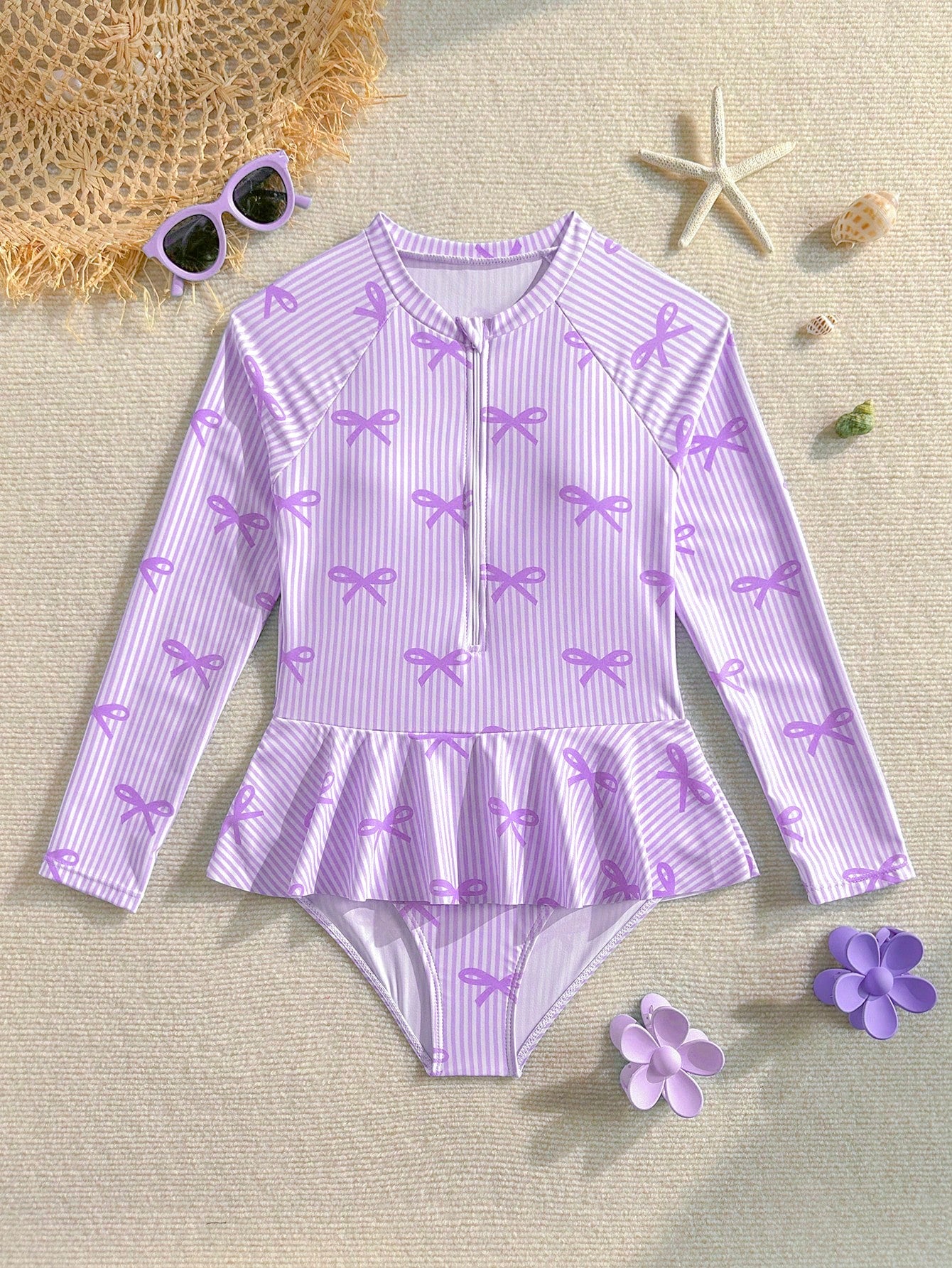 Purple tween girls one-piece swimsuit with graphic striped print, ruffle detail, round neck, and zipper closure for swimming and vacation wear