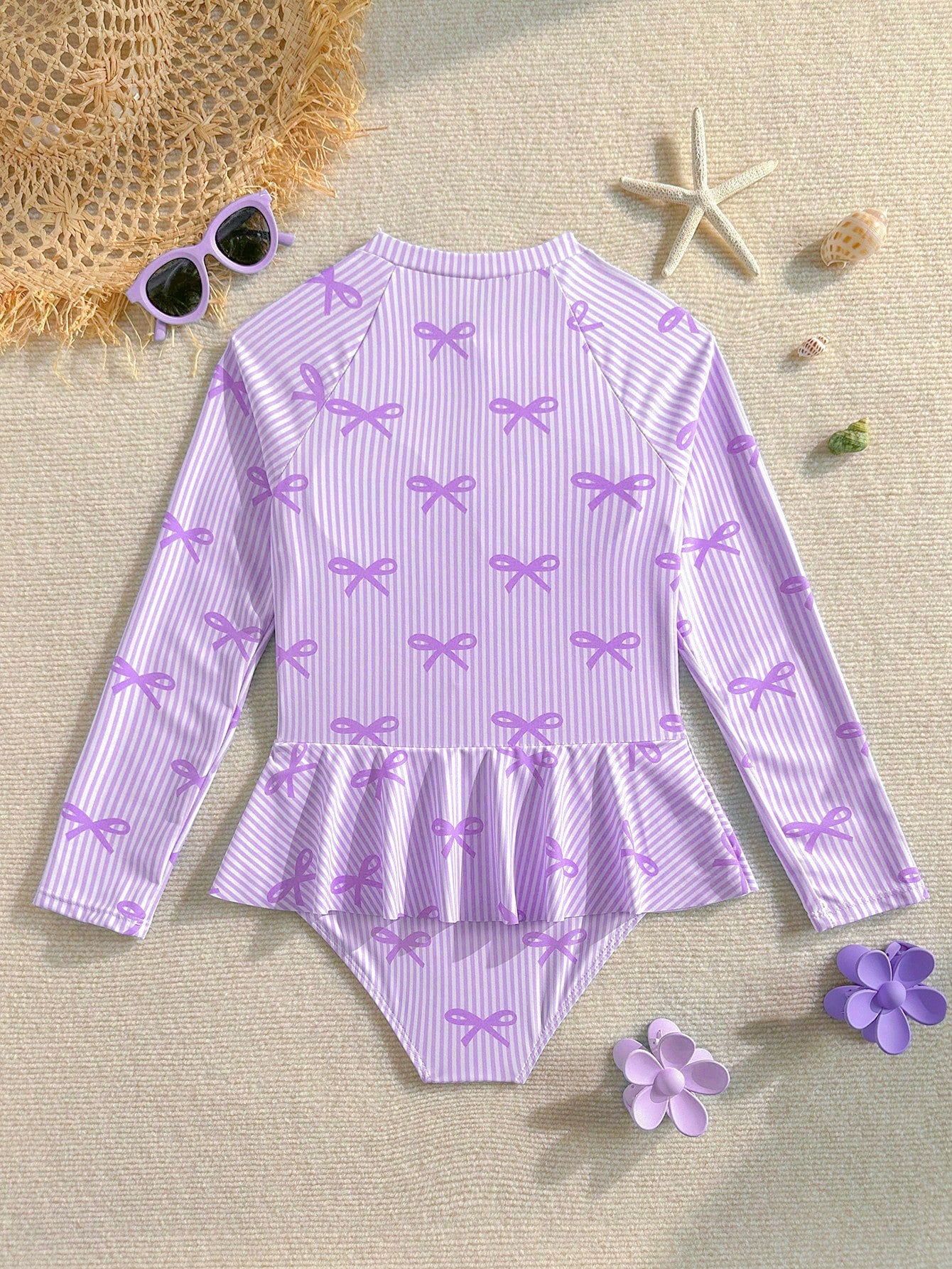 Purple tween girls one-piece swimsuit with graphic striped print, ruffle detail, round neck, and zipper closure for swimming and vacation wear