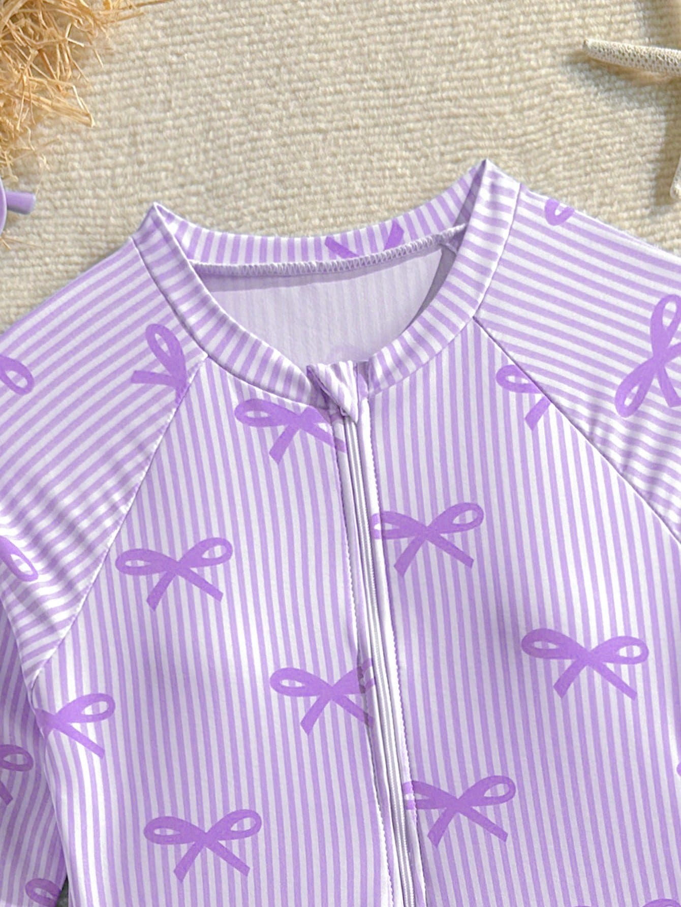 Purple tween girls one-piece swimsuit with graphic striped print, ruffle detail, round neck, and zipper closure for swimming and vacation wear