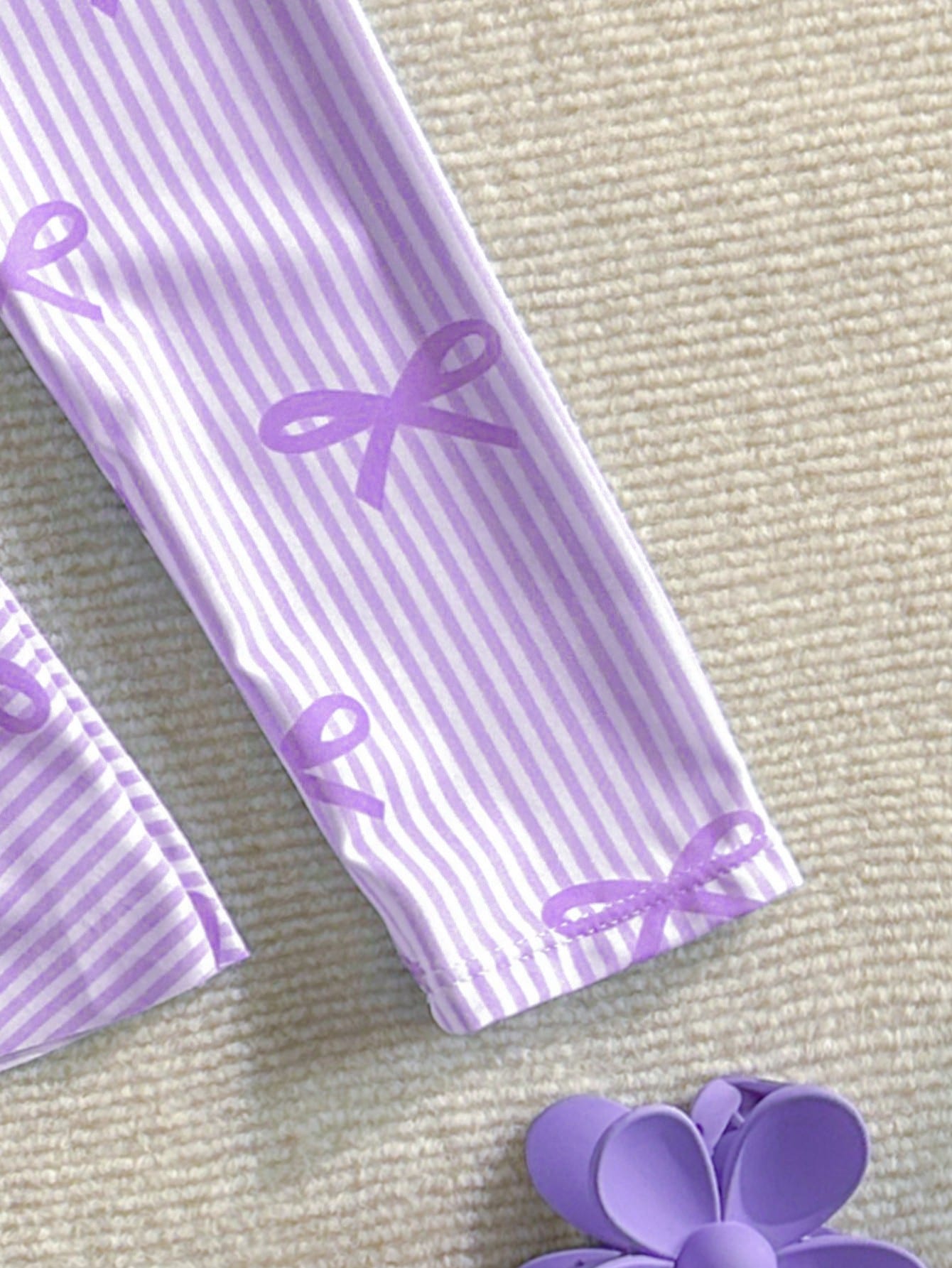 Purple tween girls one-piece swimsuit with graphic striped print, ruffle detail, round neck, and zipper closure for swimming and vacation wear