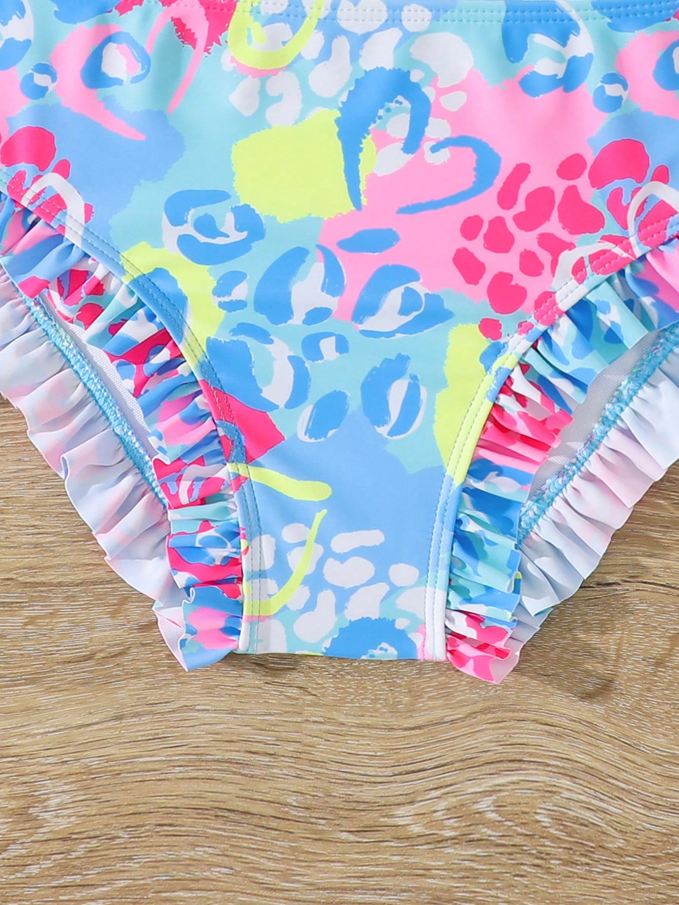 Tween girls solid color 2-piece bikini swimwear set with ruffle detail, strap neckline, wireless bikini top, and triangle mid-waist bikini bottoms; textured pattern with lined bottoms and high-stretch fabric, suitable for summer vacation.