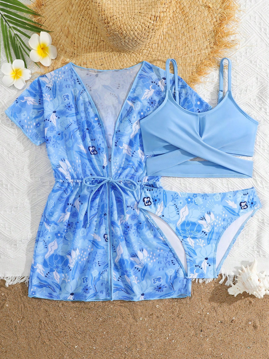 Three-piece tween girls swimwear set with a floral print, featuring a criss-cross bikini top, regular bikini bottoms, and a kimono cover-up in assorted prints.