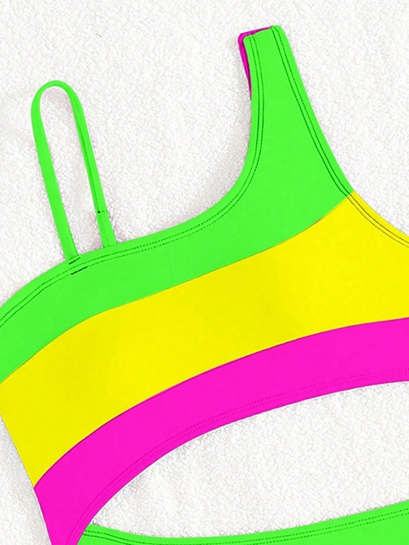 Black one-piece swimsuit for tween girls with cut out detail, spaghetti straps, high waist bottom, wireless bra, and fitted vacation swimwear style.