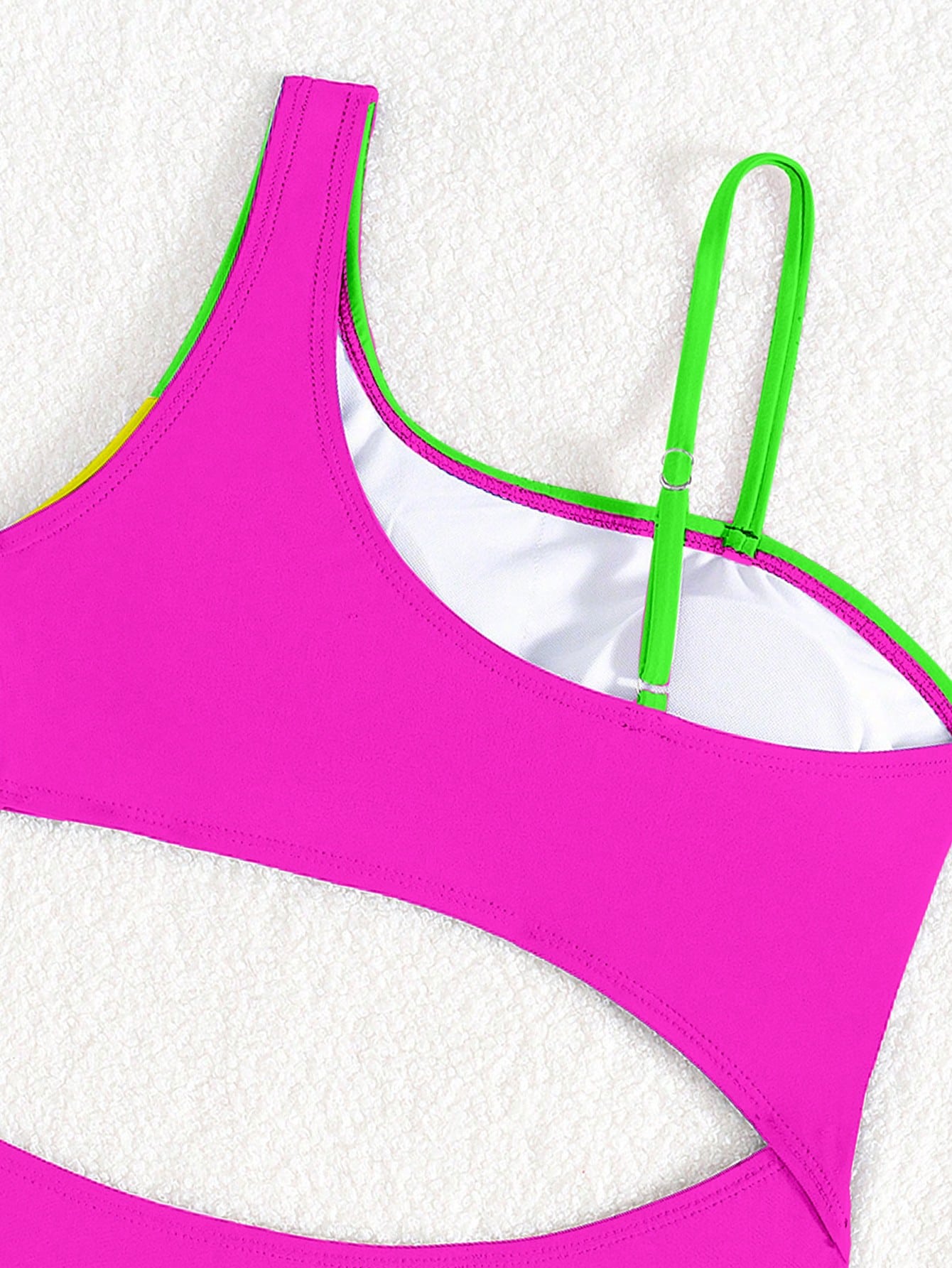 Black one-piece swimsuit for tween girls with cut out detail, spaghetti straps, high waist bottom, wireless bra, and fitted vacation swimwear style.