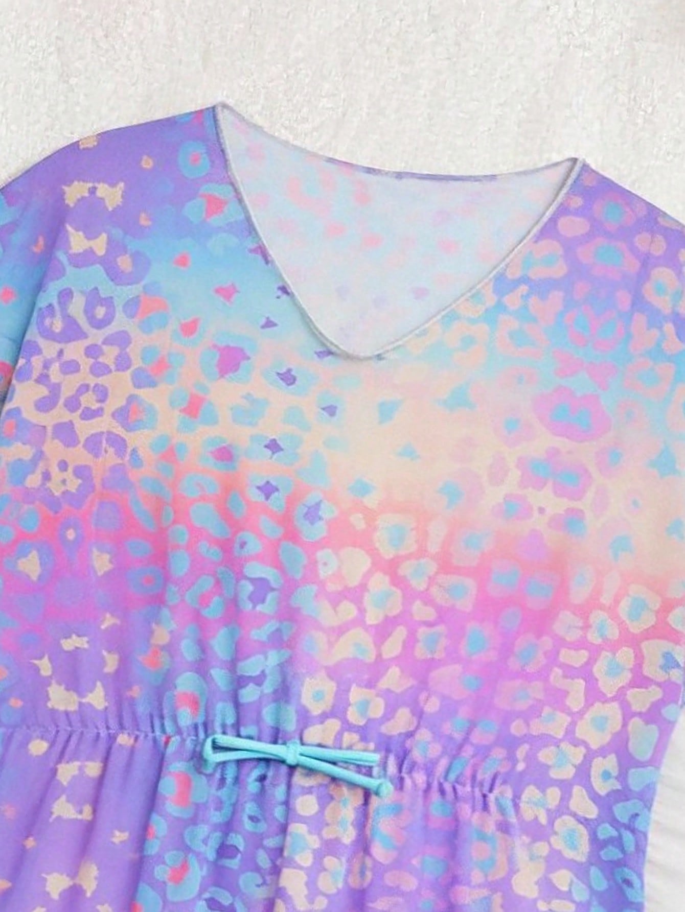Blue tween girls swimsuit cover up with geometric starfish print, ruffle trim, round neck, short sleeves, and semi-sheer knit fabric for beach or pool wear.