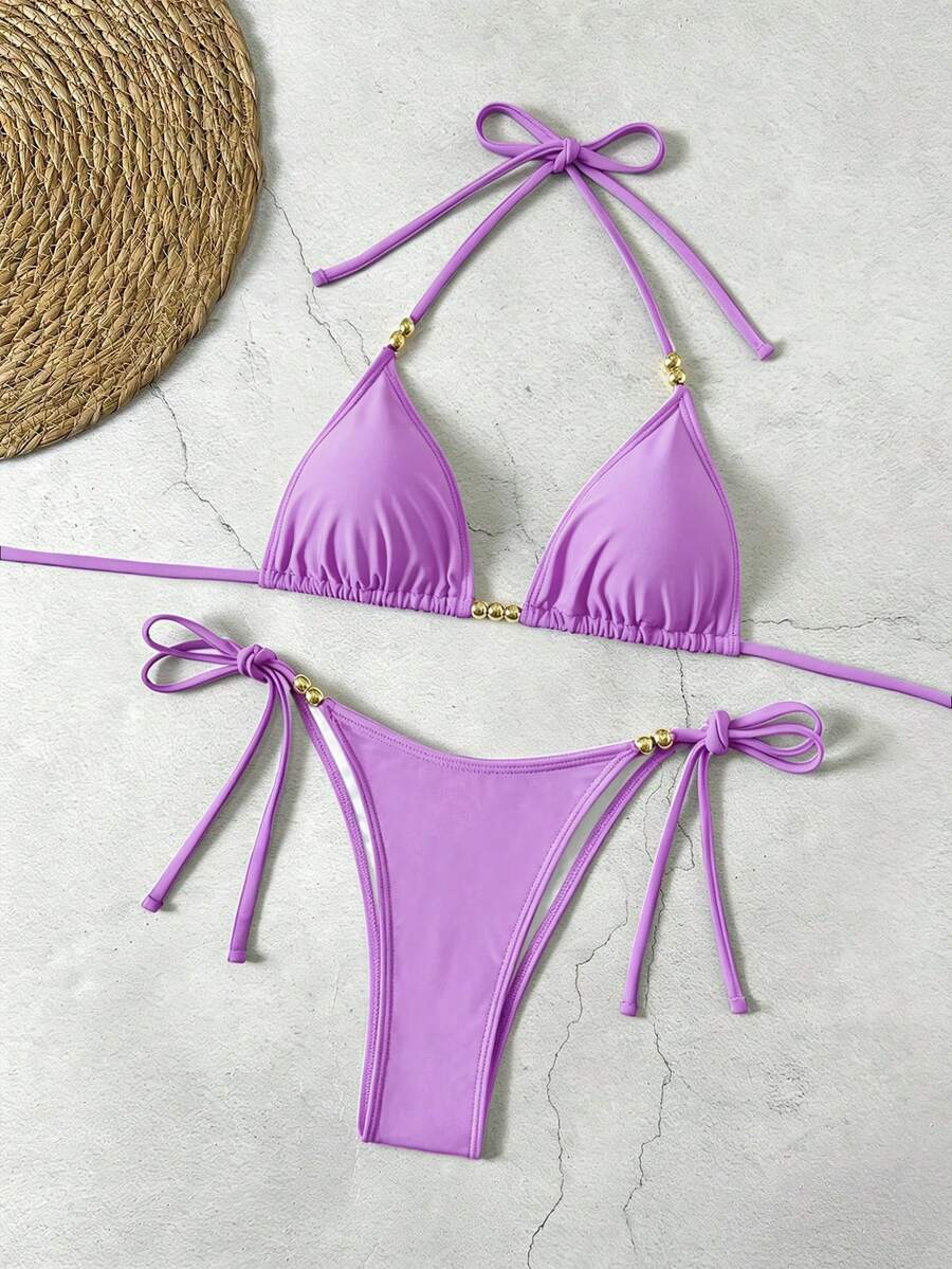 Women's black halter bikini set featuring triangle cups with gold bead decor and tie-back closure