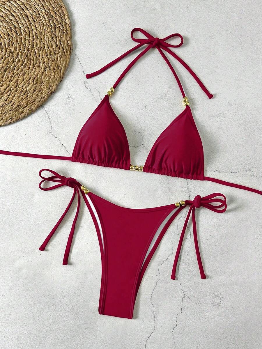 Women's black halter bikini set featuring triangle cups with gold bead decor and tie-back closure