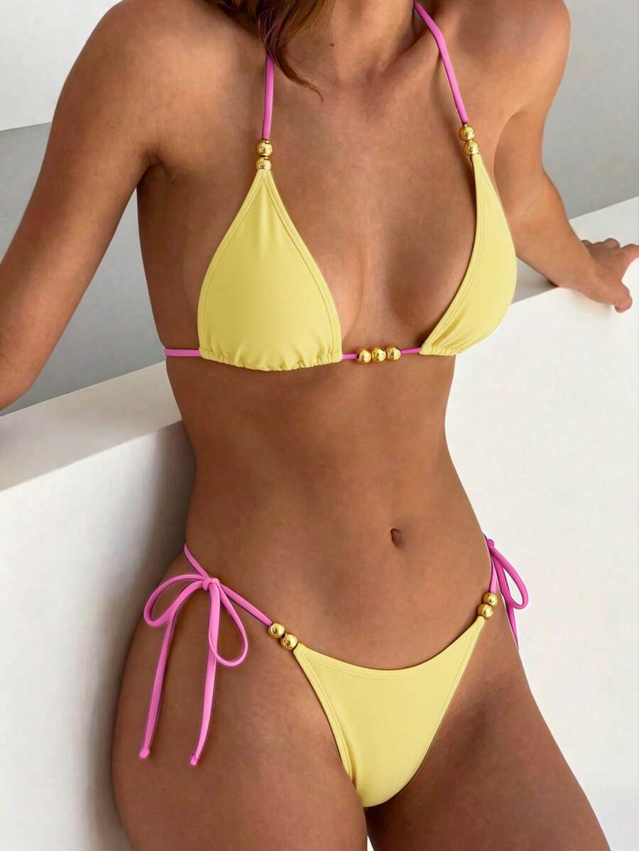 Women's black halter bikini set featuring triangle cups with gold bead decor and tie-back closure
