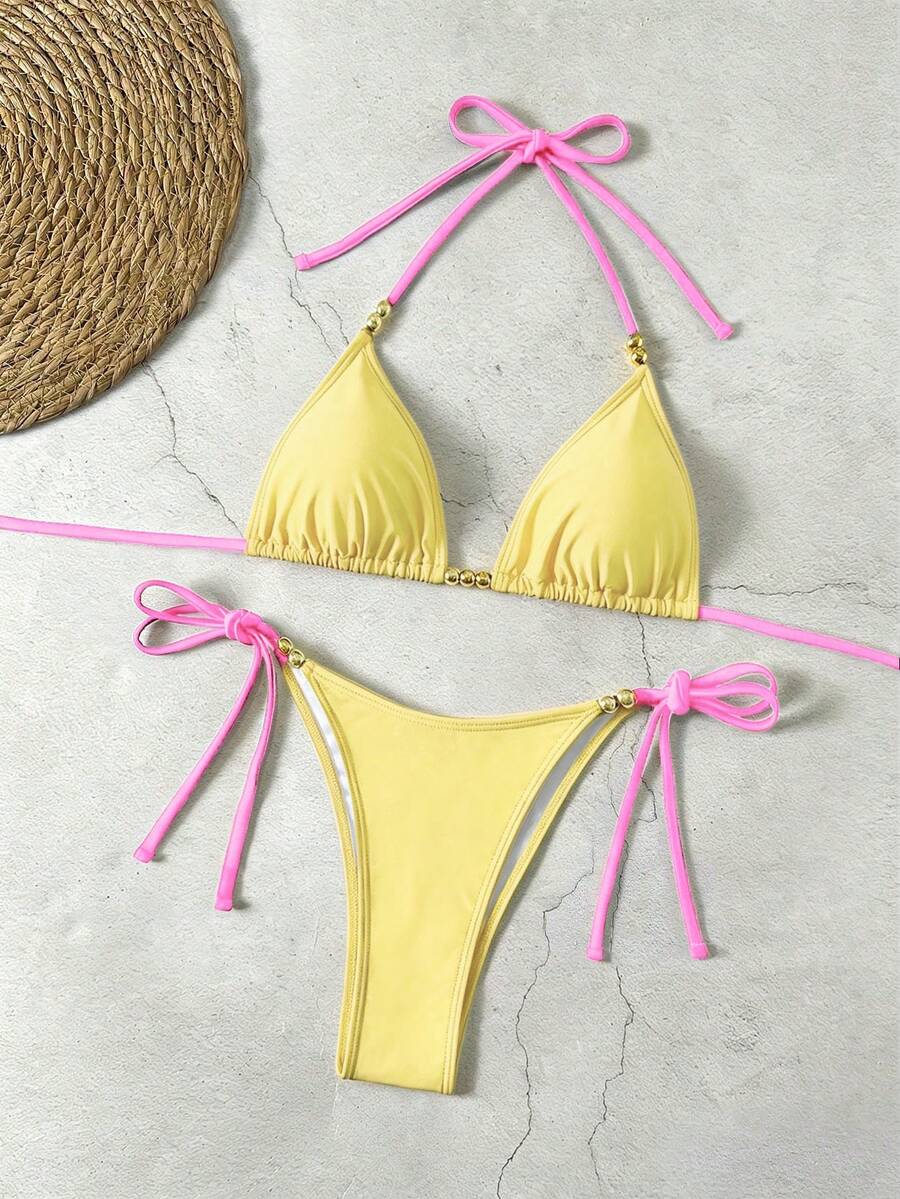 Women's black halter bikini set featuring triangle cups with gold bead decor and tie-back closure
