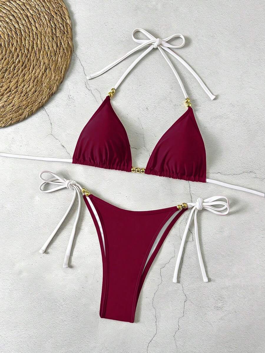 Women's black halter bikini set featuring triangle cups with gold bead decor and tie-back closure