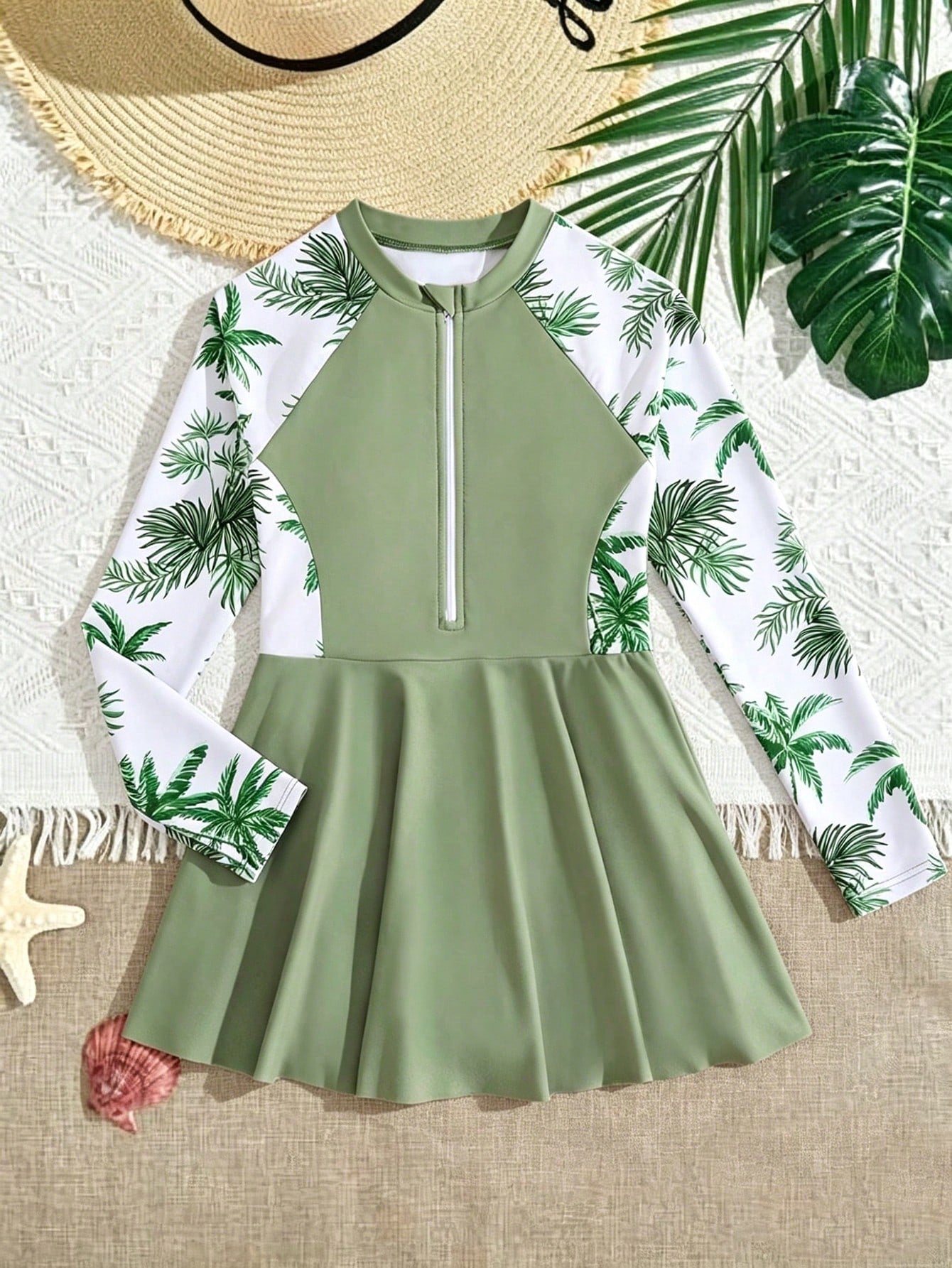 Tween girls one-piece swimsuit in black floral pattern with long sleeves, high neck, front zipper, and a skirt-style bottom.