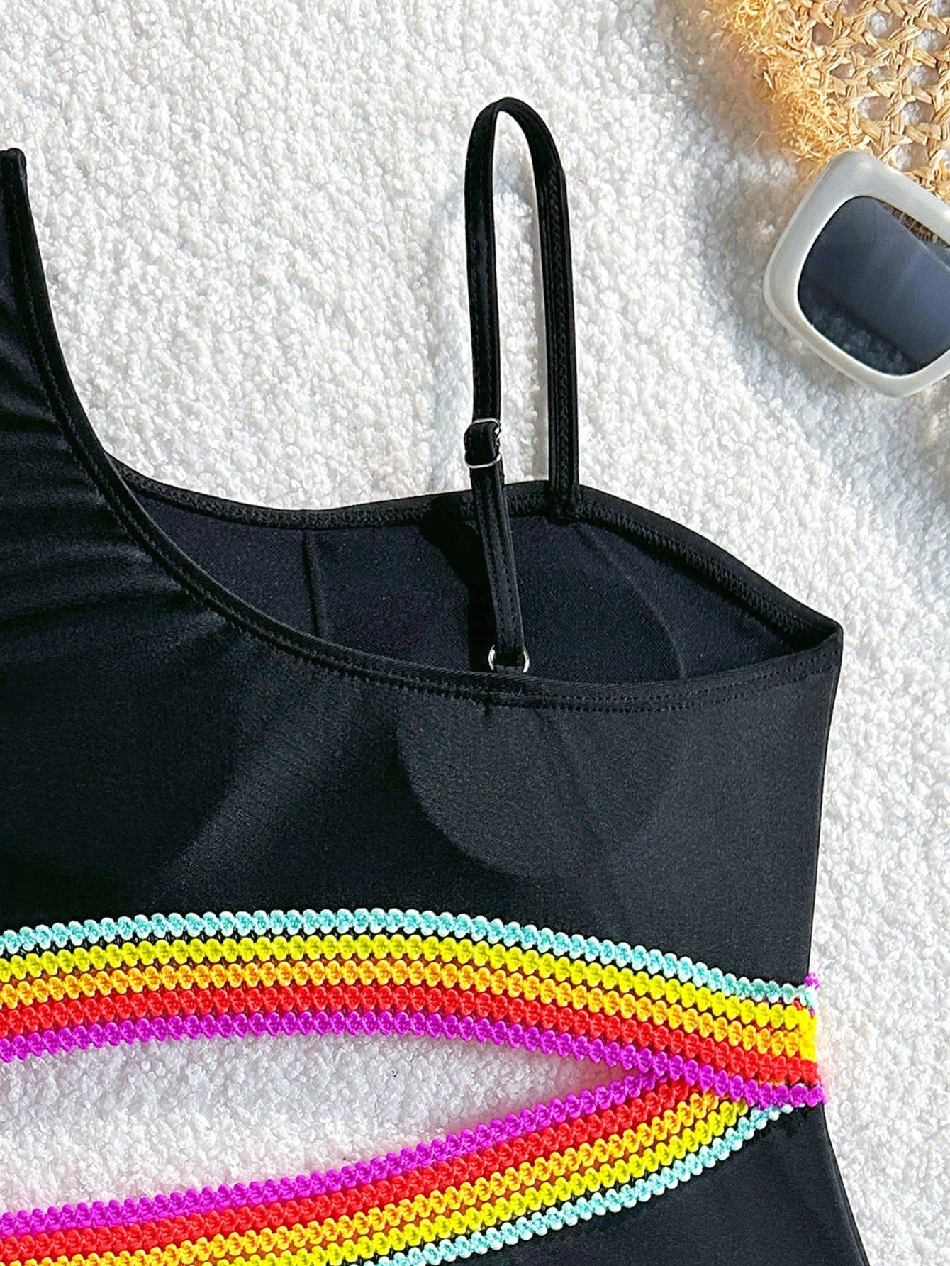 Black one-piece swimsuit for tween girls with cut out detail, spaghetti straps, high waist bottom, wireless bra, and fitted vacation swimwear style.
