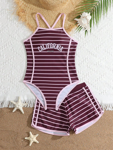 Girls' mauve purple one-piece swimsuit with swim shorts, spaghetti straps, contrast piping, letter pattern, and sleeveless vacation swimwear design.