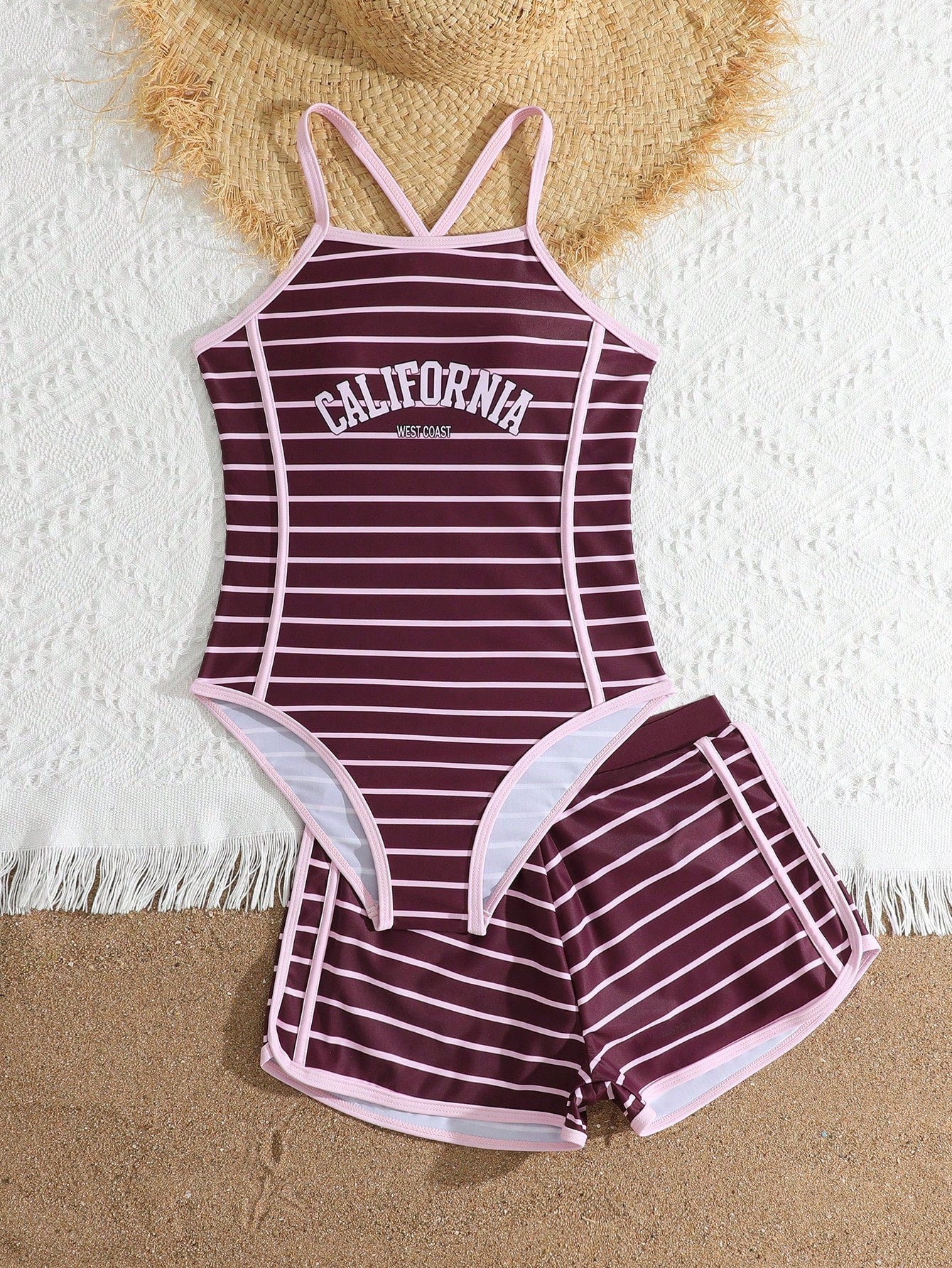 Girls' mauve purple one-piece swimsuit with swim shorts, spaghetti straps, contrast piping, letter pattern, and sleeveless vacation swimwear design.