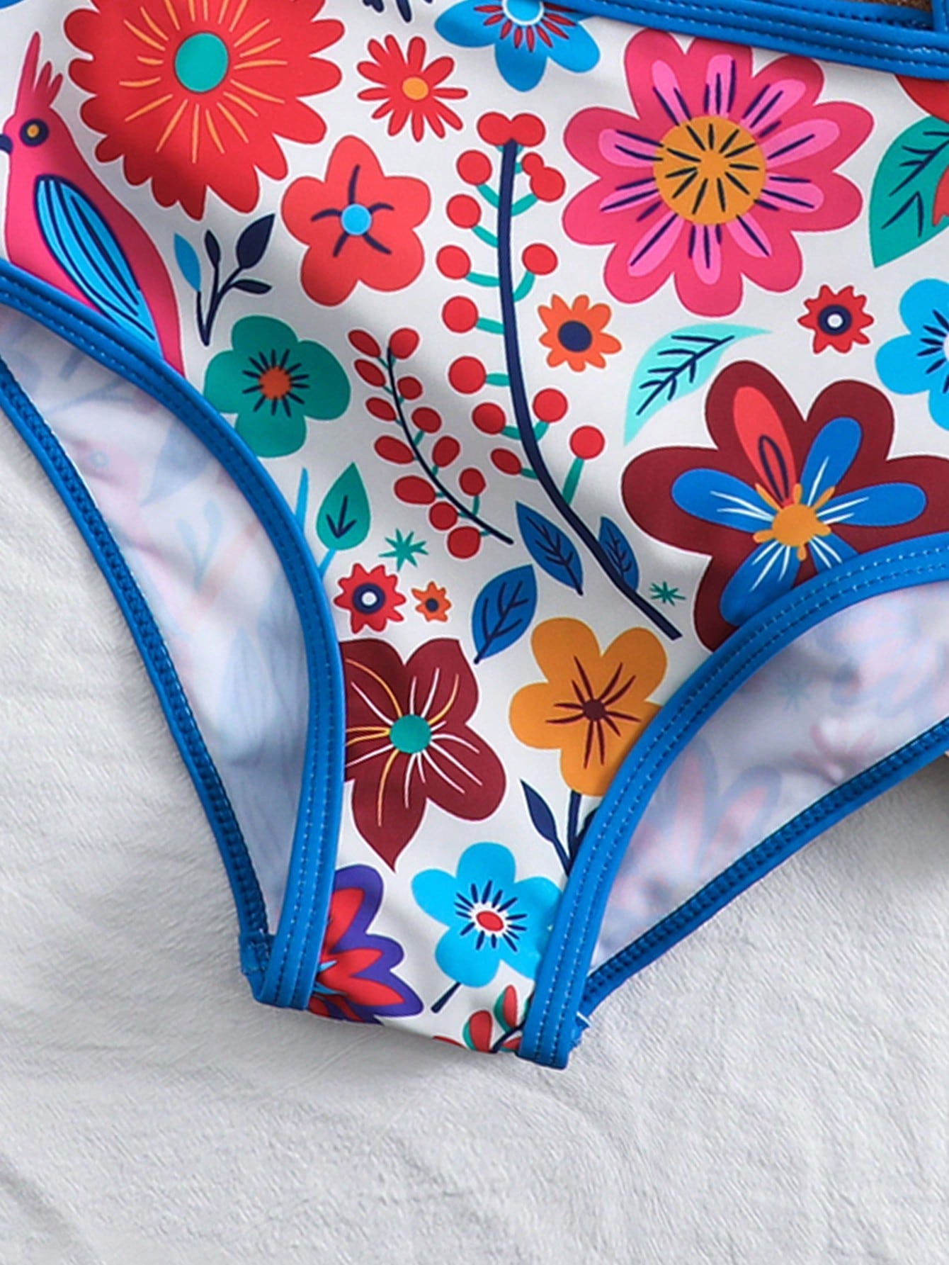 Tween girls one-piece swimsuit featuring an asymmetric neckline, pendant decor, plain design, wireless bra, high-cut bottom, and medium-stretch fabric.